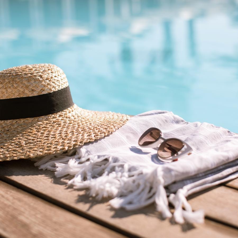 a hat and sunglasses by a pool